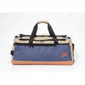 A color-blocked duffle bag by Protect-The-West-Coast featuring a navy blue front panel, a beige top section, and a tan bottom base, with black straps and zippers.